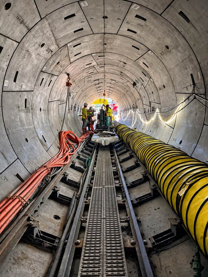 Interior del túnel Cemetery Brook revestido con anillos de hormigón, con operarios al fondo, el 24 de septiembre de 2026