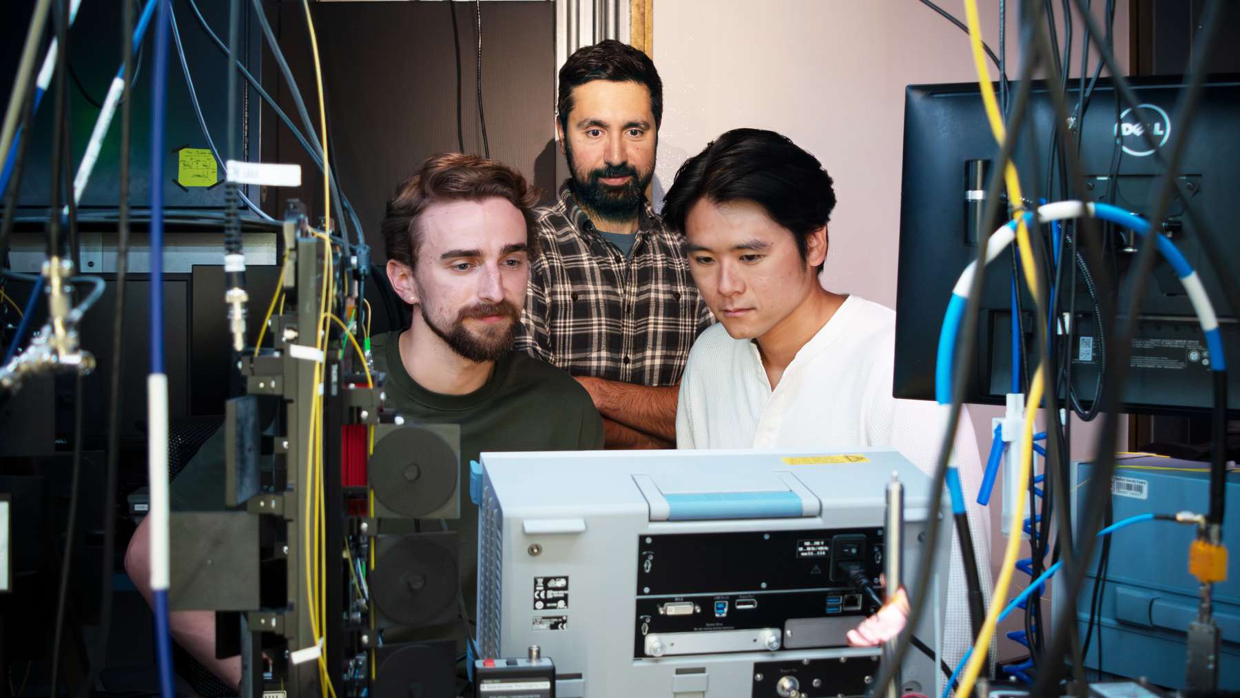 Erik Szakiel, Amir Safavi-Naeini y Takuma Makihara, autores del estudio sobre los saltos cuánticos del sonido, en su laboratorio de Stanford