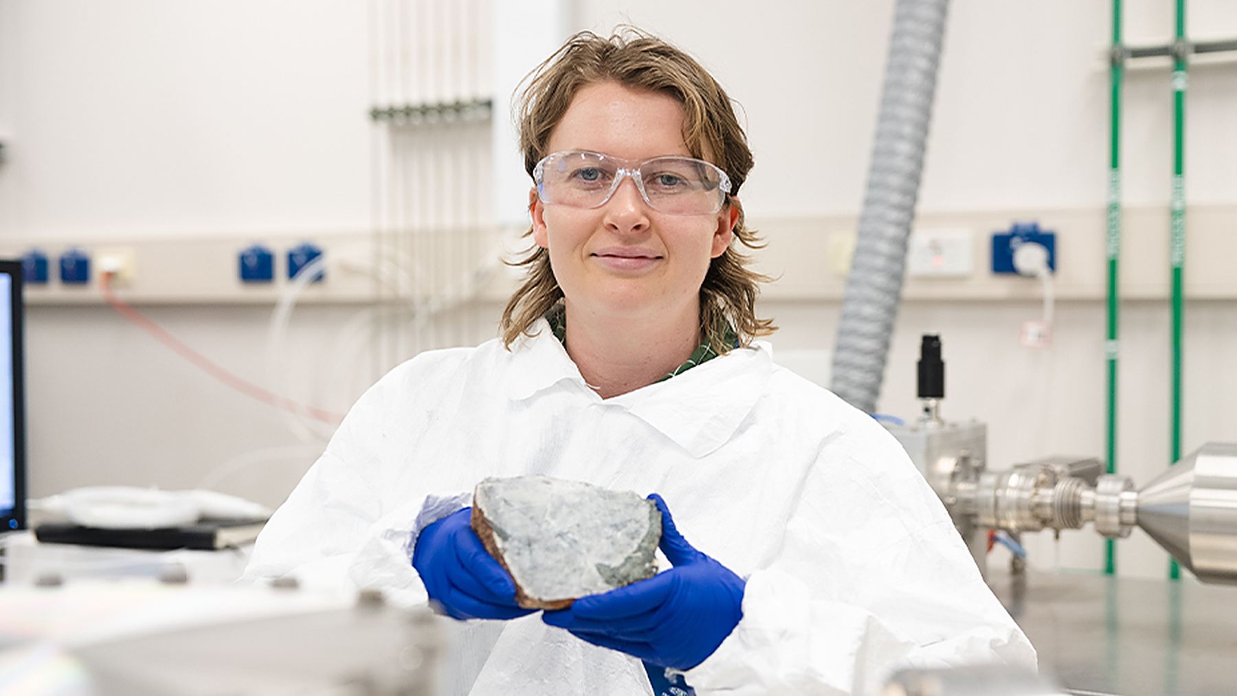 Matilda Boyce sostiene en el laboratorio una anortosita de Australia Occidental, roca clave para estudiar el nacimiento de la Luna