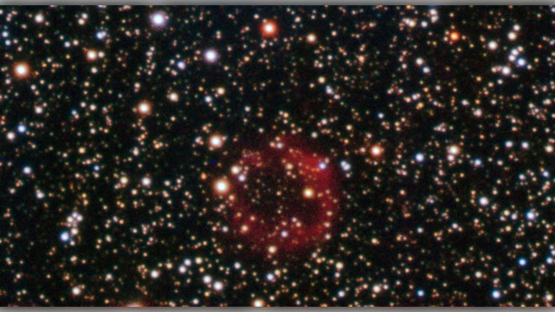 Imagen del objeto de Sakurai, con su envoltura rojiza de gas y polvo rodeada de estrellas
