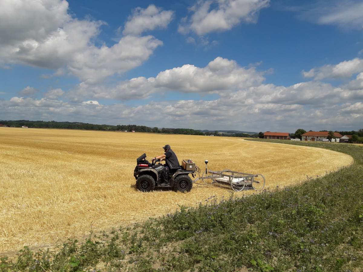 Quad con equipos de prospección geofísica sobre un campo de Stein, Austria