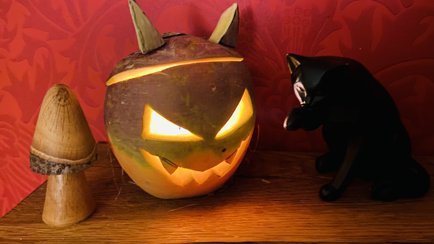 Linterna de Halloween tallada en un nabo junto a un gato negro