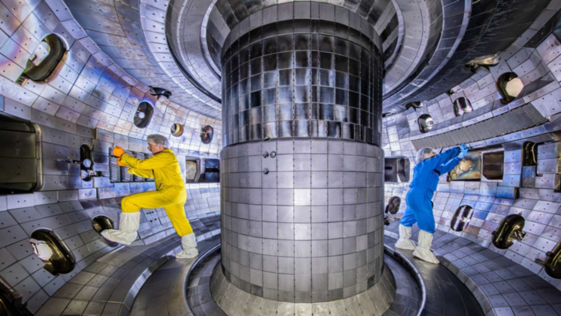 Dos técnicos trabajan dentro de la cámara de vacío del tokamak DIII-D, donde el sistema PACMAN anticipó una inestabilidad del plasma
