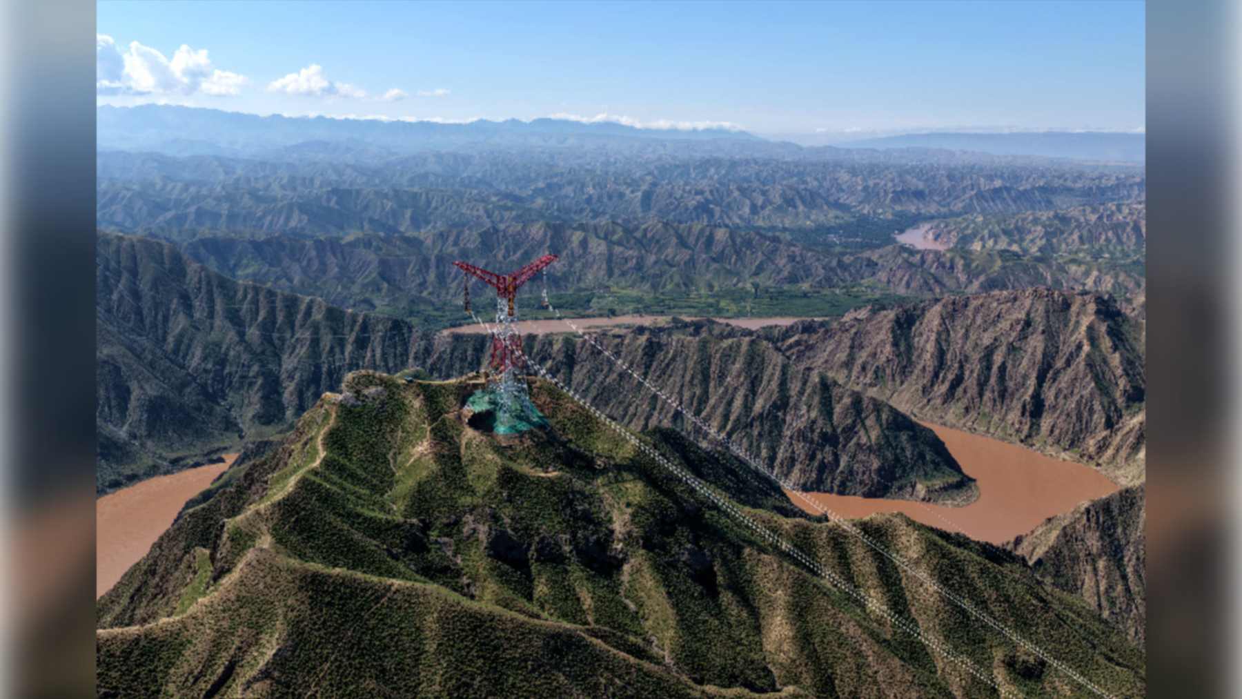 Torre de alta tensión de la línea Gansu-Zhejiang sobre las montañas junto al río Amarillo, en Gansu