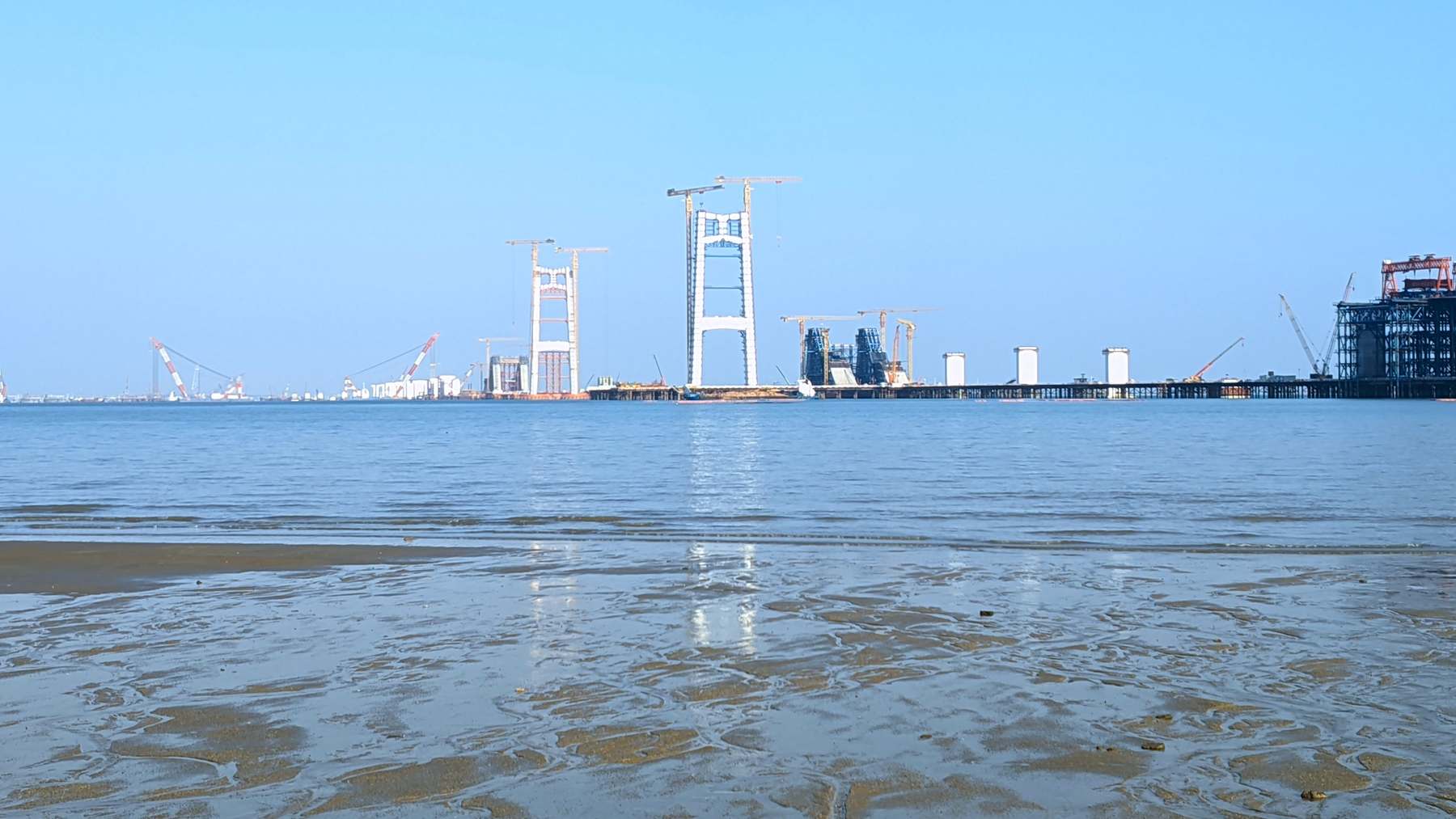 Torres del puente colgante de Liuwudian en obras vistas desde una playa de Xiamen