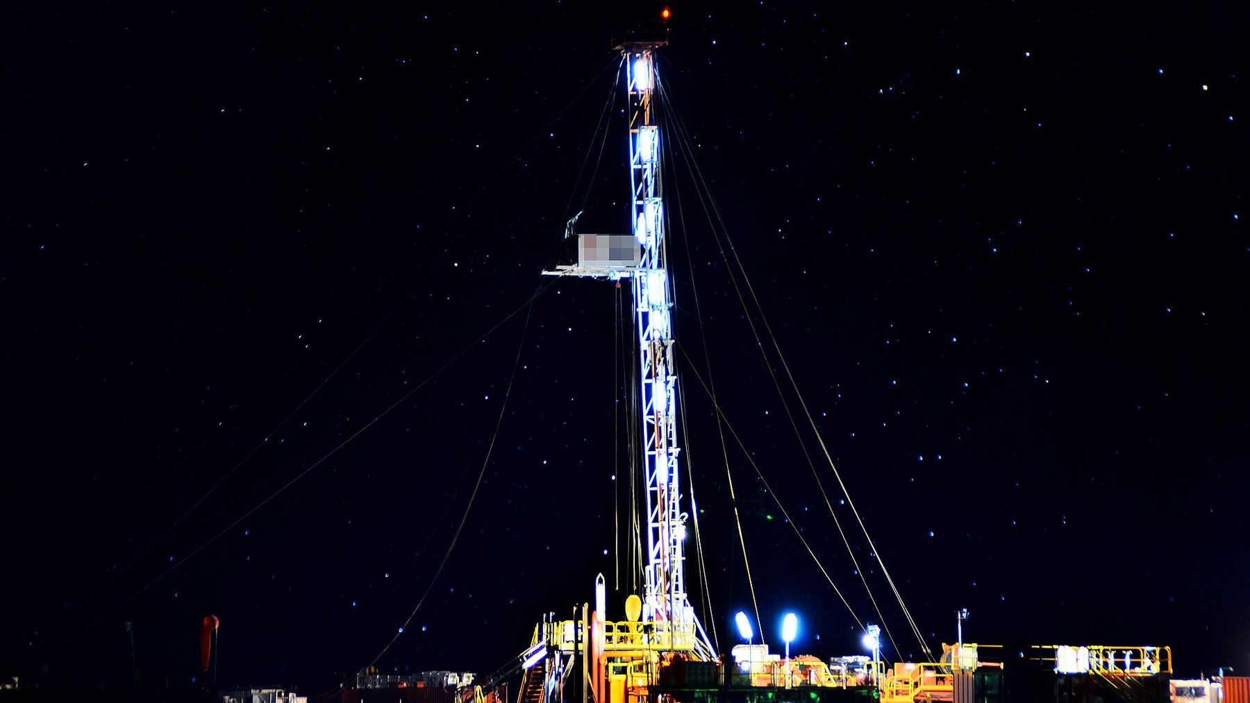 Equipo de perforación iluminado de noche en Añelo, en Vaca Muerta, con récord de barriles diarios de petróleo