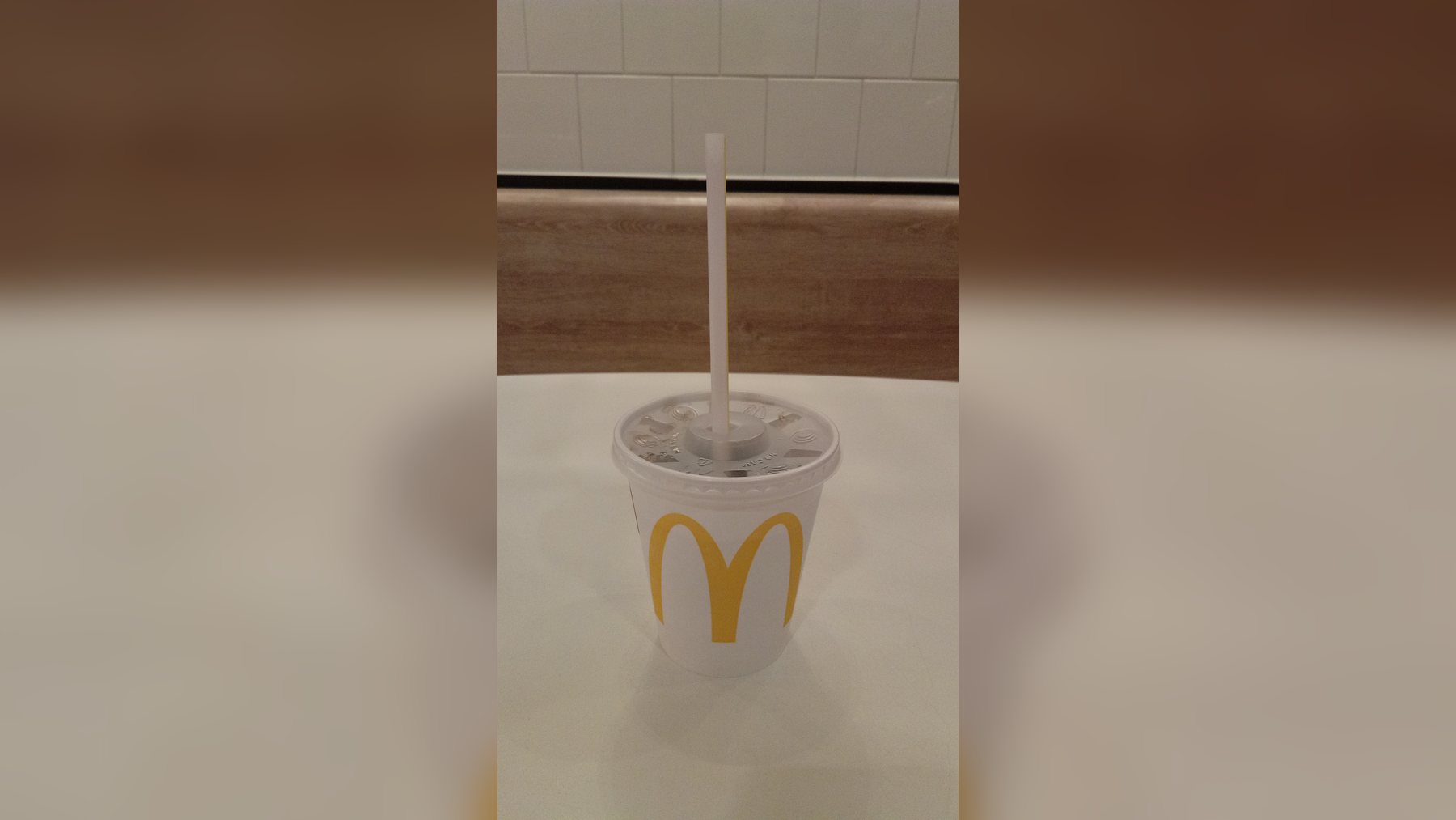 Vaso desechable de refresco con el logotipo de McDonald's sobre una mesa vasos reutilizables