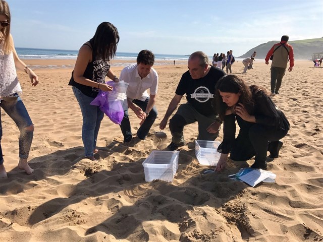 Estudiantes participan en la recogida de microplásticos en la playa de Zarautz