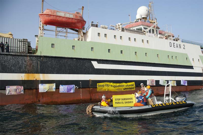 Greenpeace pega billetes de euro de gran tamaño en el casco de un arrastrero pelágico alemán