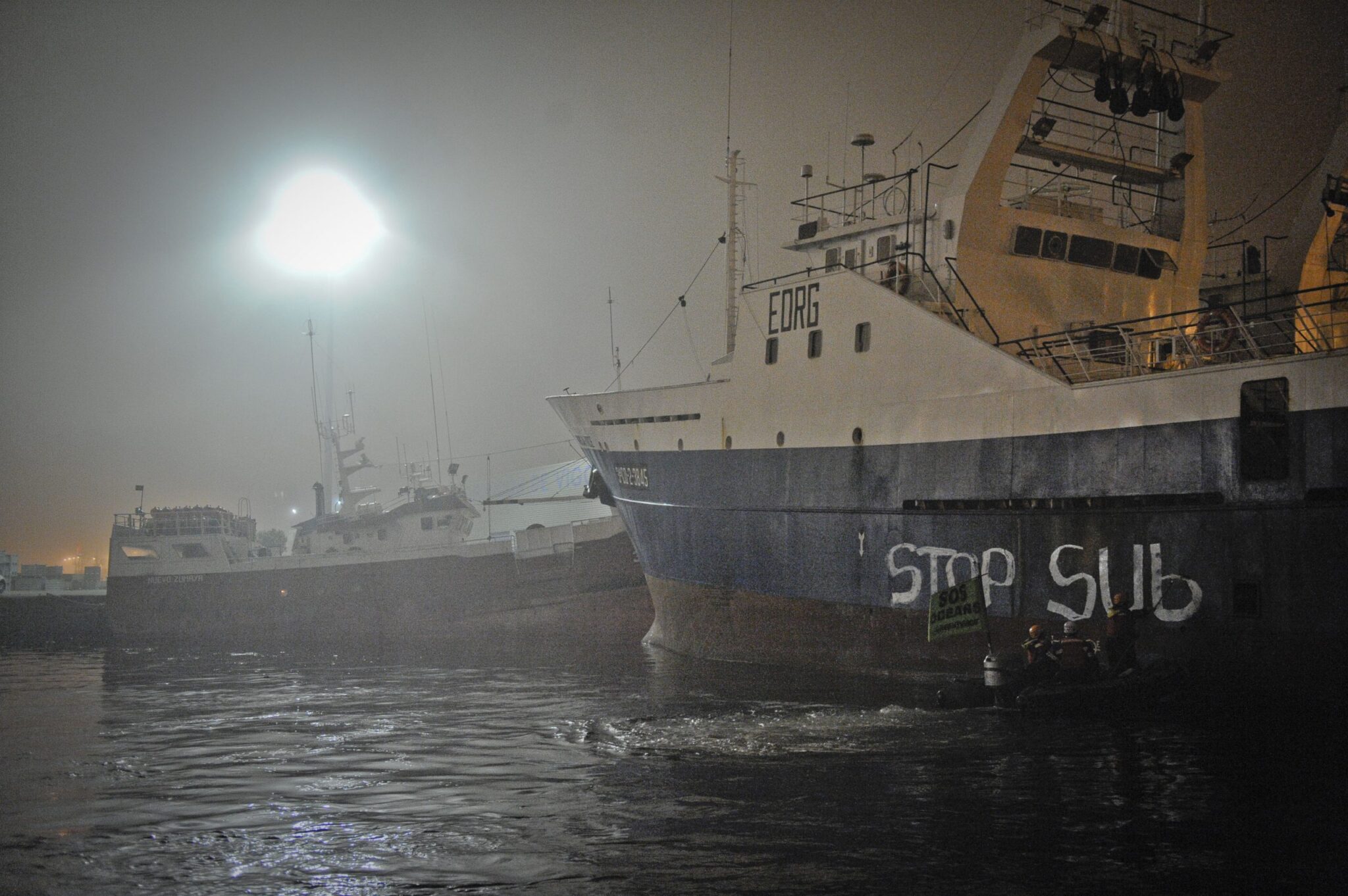Activistas de Greenpeace pintan barcos arrastreros en Vigo para denunciar la sobreexplotación de los océanos