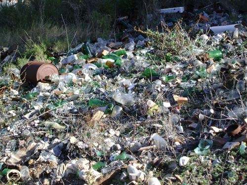 Vertedero ilegal de botellas en un barranco próximo al balneario de Cofrentes