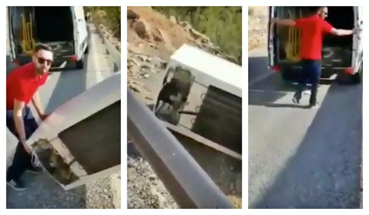 Un trabajador de una empresa de residuos se deshace de un frigorífico echándolo monte abajo