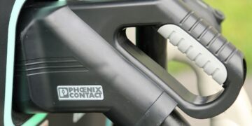 Vista de camiones y autobuses junto a puntos de recarga eléctrica e hidrogeneras en España financiados por Bruselas para descarbonizar el transporte