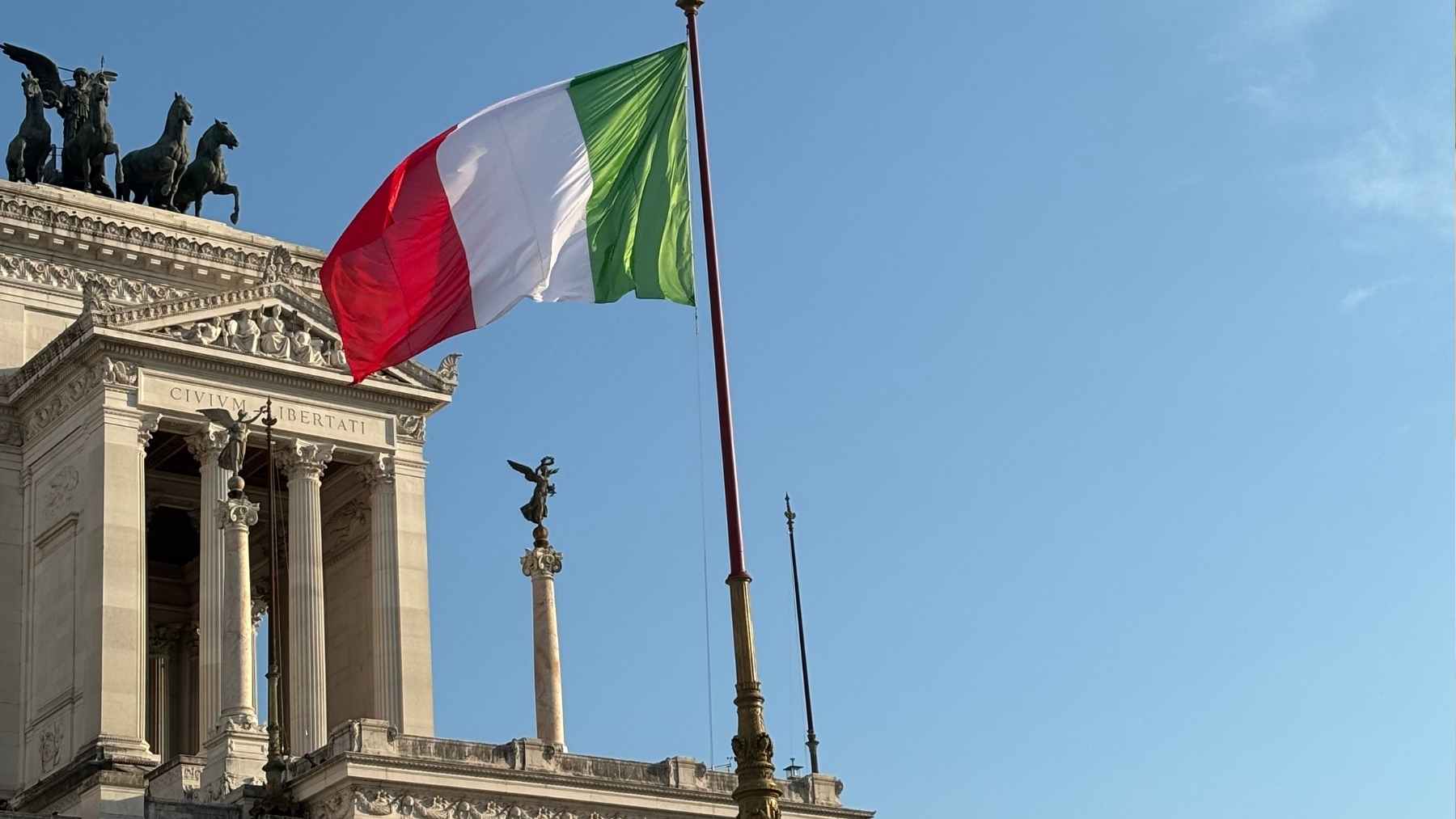 Bandera de Italia ondeando en un edificio institucional en Roma