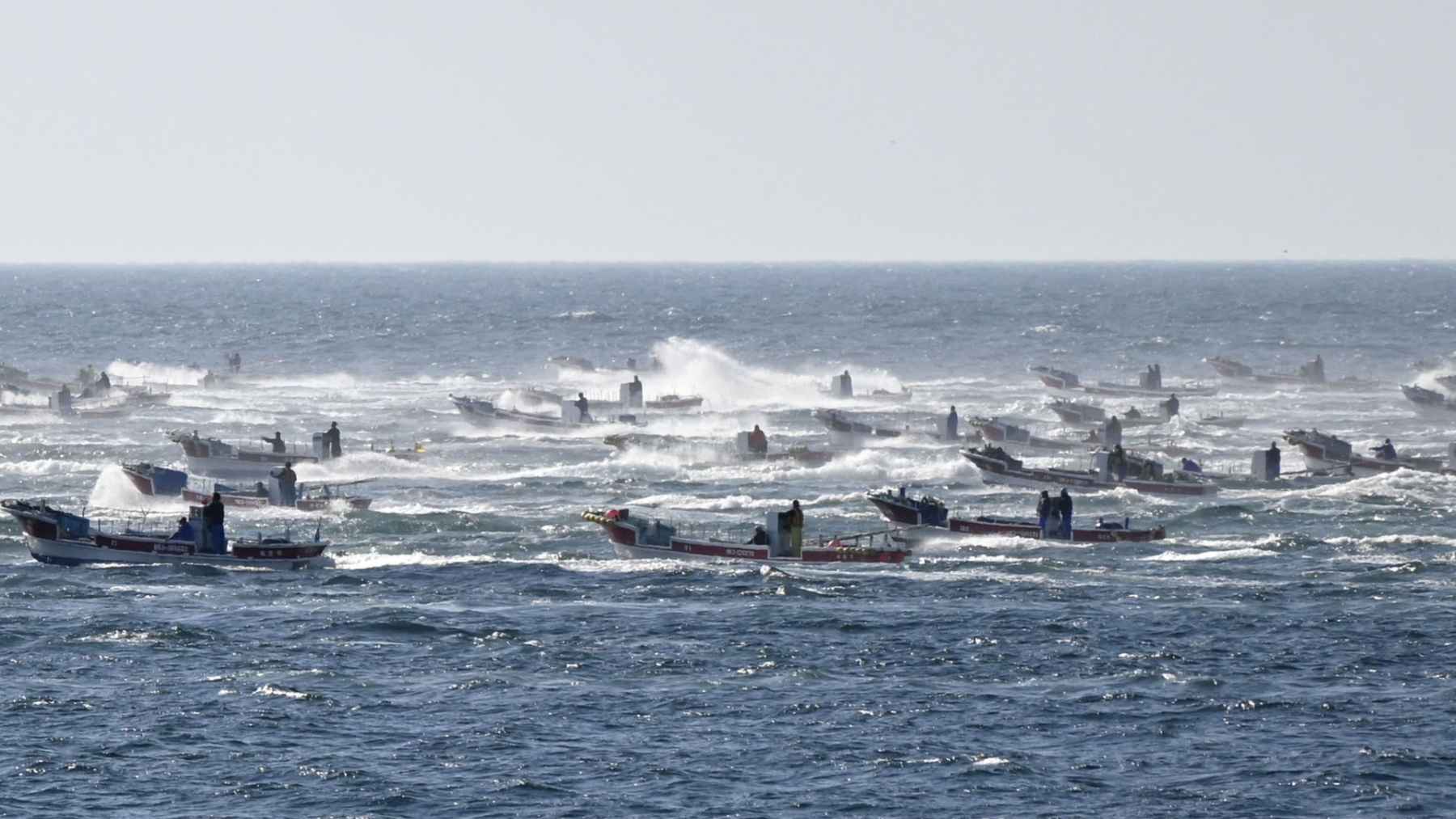 Barcos pesqueros faenando frente a Japón en mar agitado, con aguas más cálidas por el desplazamiento de la Kuroshio.