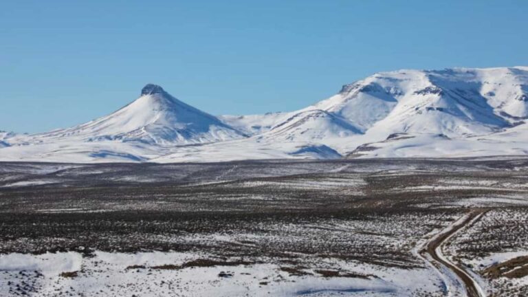 Paisaje de montañas cubiertas de nieve en una extensa llanura durante el invierno