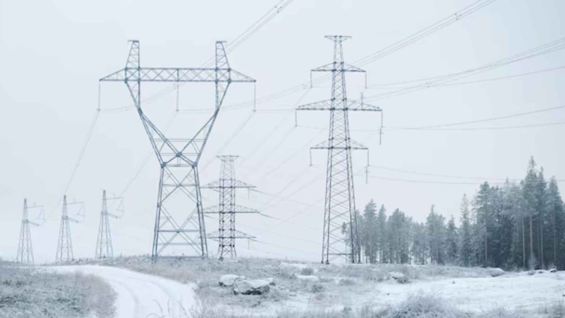 Torres de alta tensión en Finlandia bajo nieve intensa durante una crisis energética invernal.