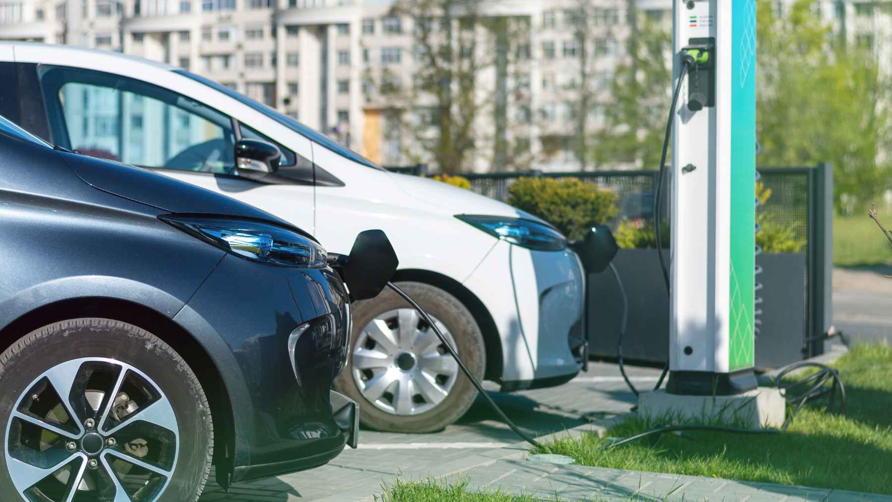 Coches eléctricos cargando en un punto de recarga público conectado a la red eléctrica urbana
