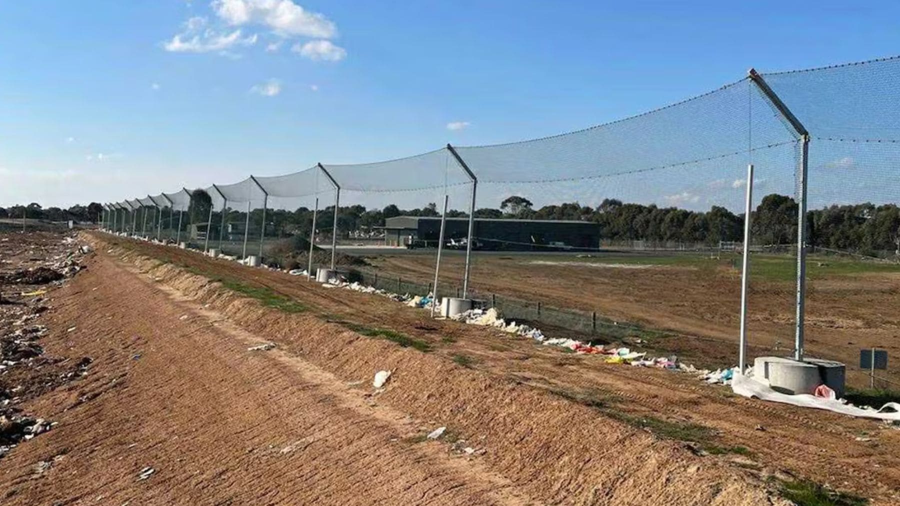 Vallas de contención en un vertedero de Australia para evitar que la basura llegue a campos y fauna.
