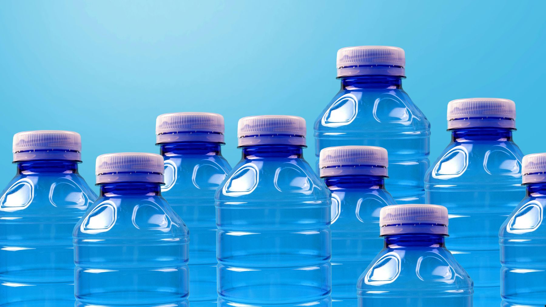 Botellas de plástico PET con tapón unido que serán más turbias en Europa desde 2030 por el uso de plástico reciclado.