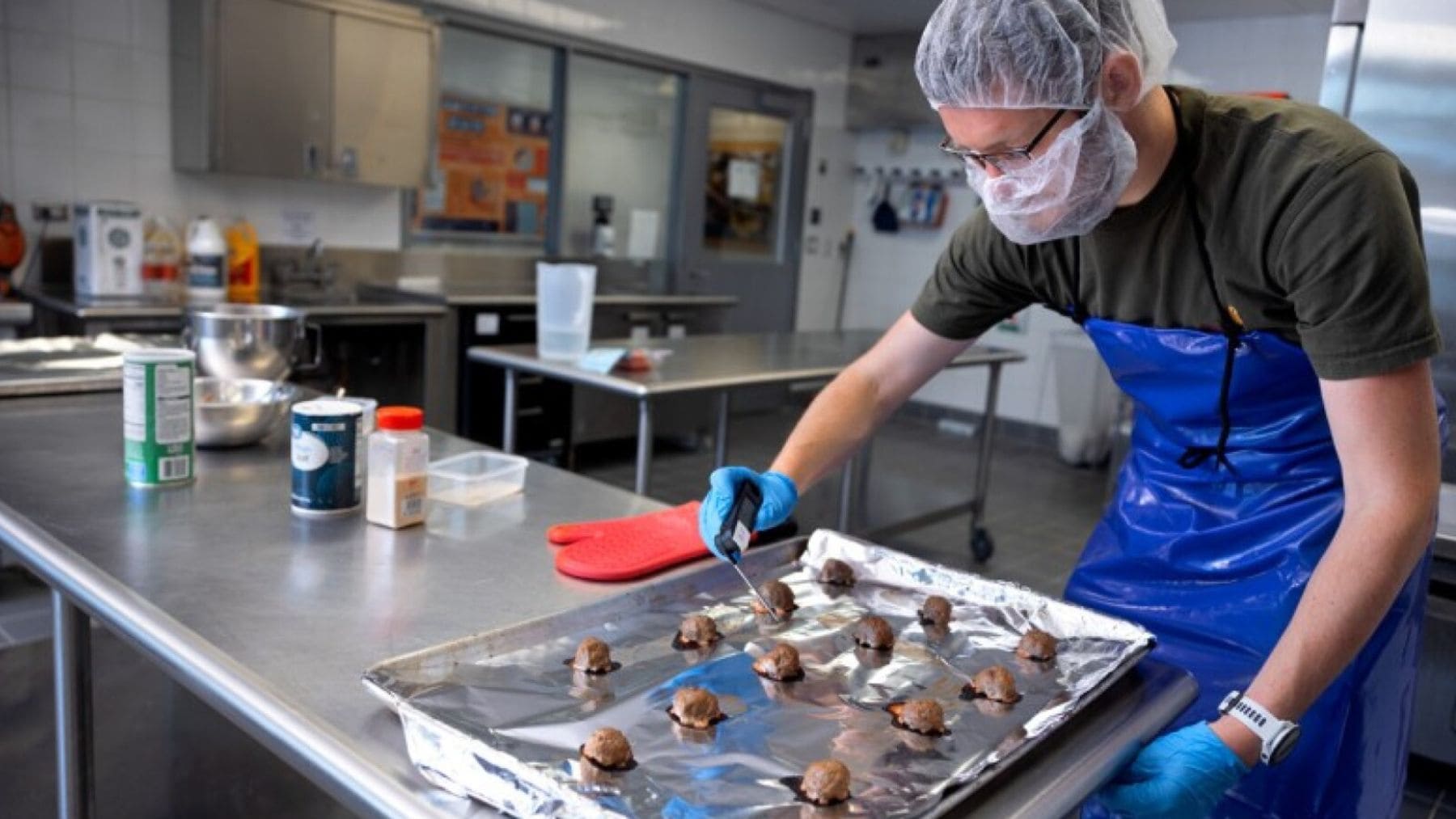 Investigador de Cornell preparando albóndigas con 20% de orujo de manzana en laboratorio alimentario.