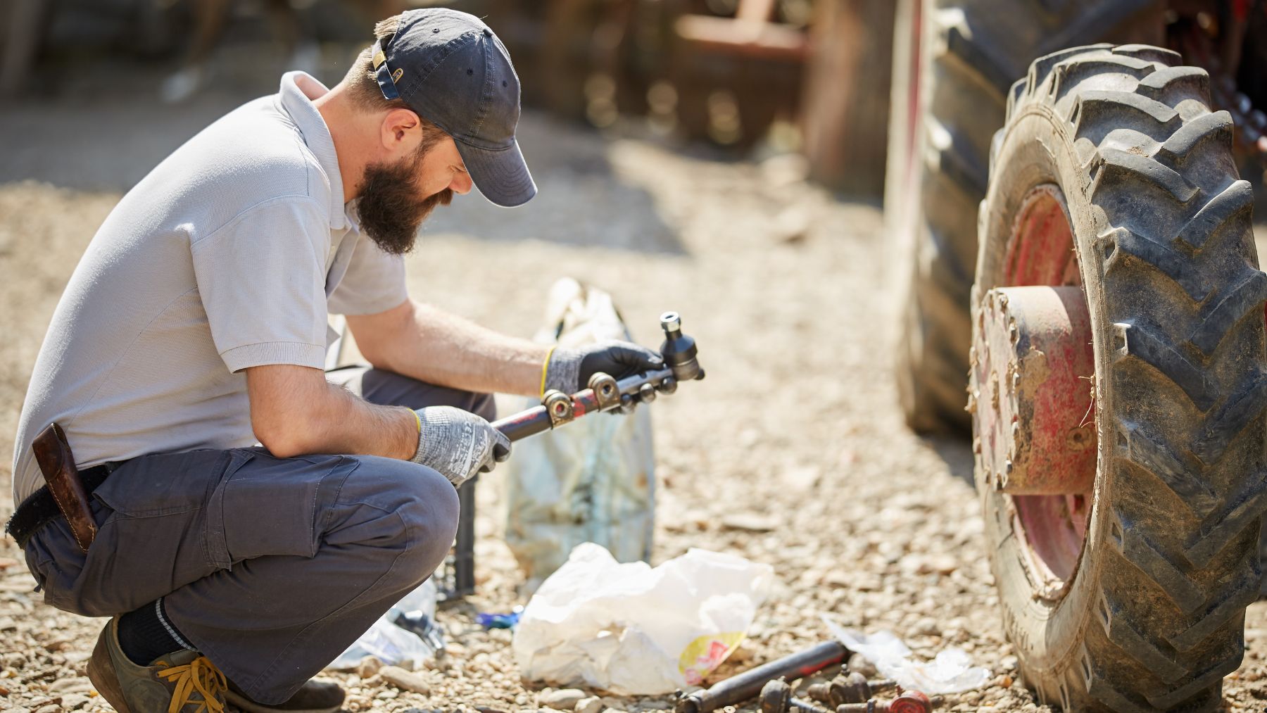 Agricultor reparando la rueda de un tractor tras la guía de la Ley de Aire Limpio sobre derecho a reparar.