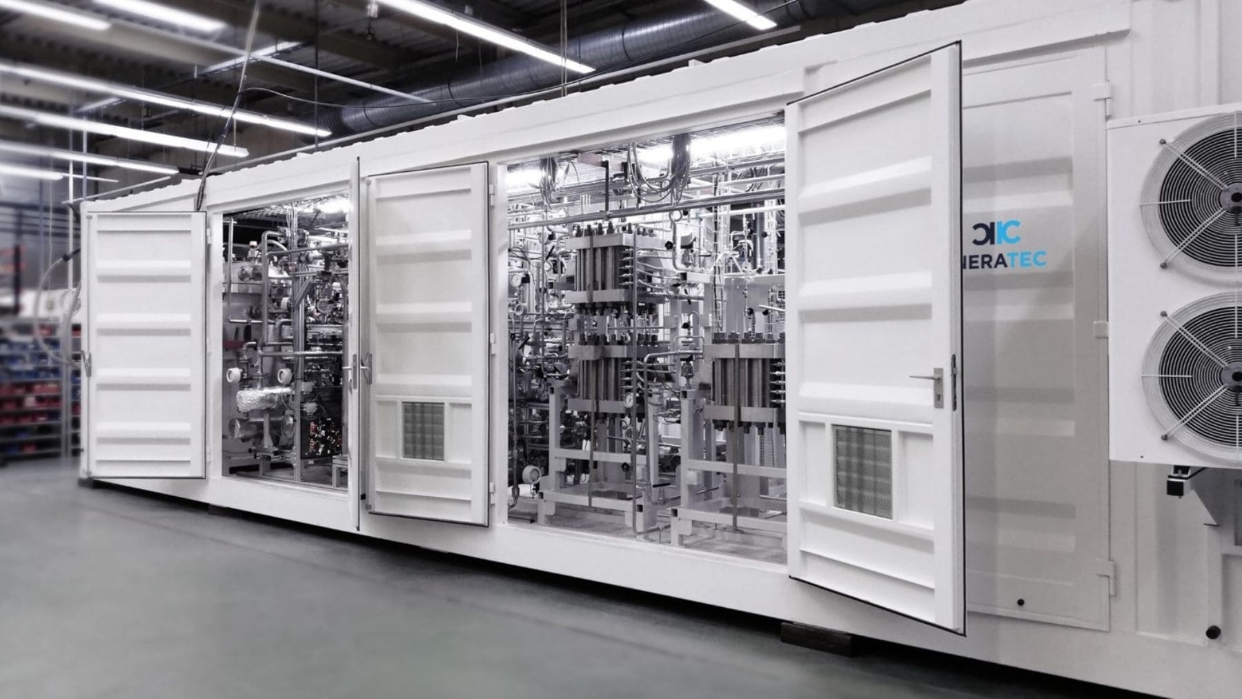 La imagen muestra un módulo industrial tipo contenedor con sistemas de electrólisis / producción de hidrógeno.