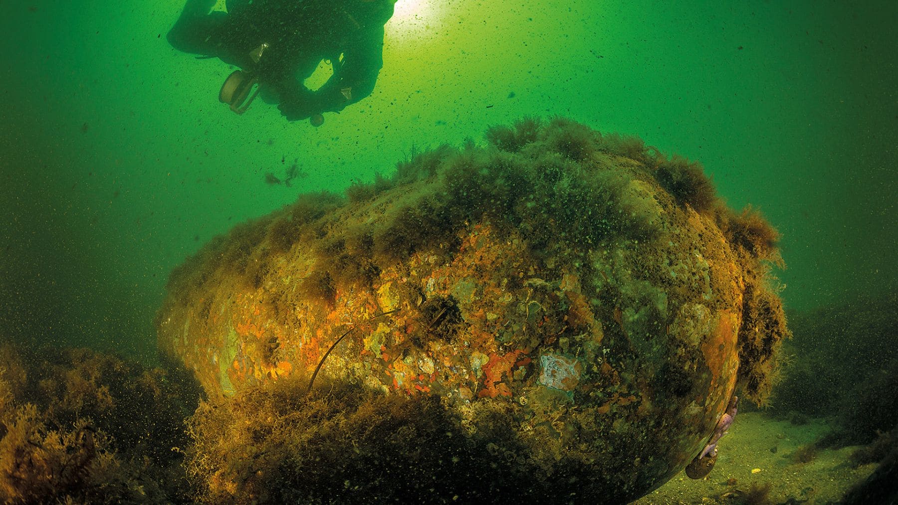 Bomba química de la Segunda Guerra Mundial oxidándose en el fondo del mar Báltico junto a un buzo investigador.