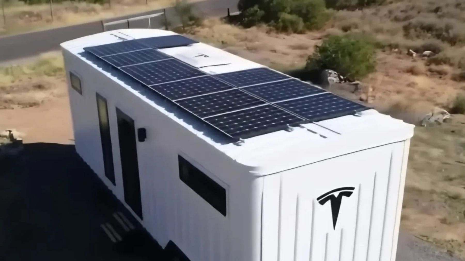 Casa Tesla modular con paneles solares, batería Powerwall y coche eléctrico cargando.