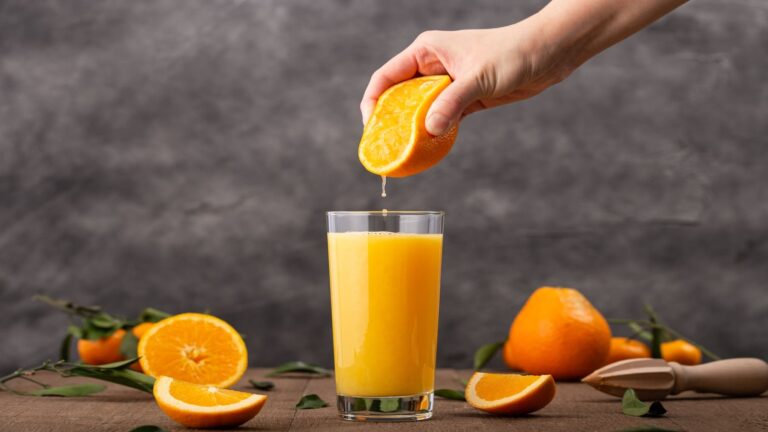 Vaso de zumo de naranja natural que demuestra que el azúcar del zumo de naranja no se absorbe igual que el añadido