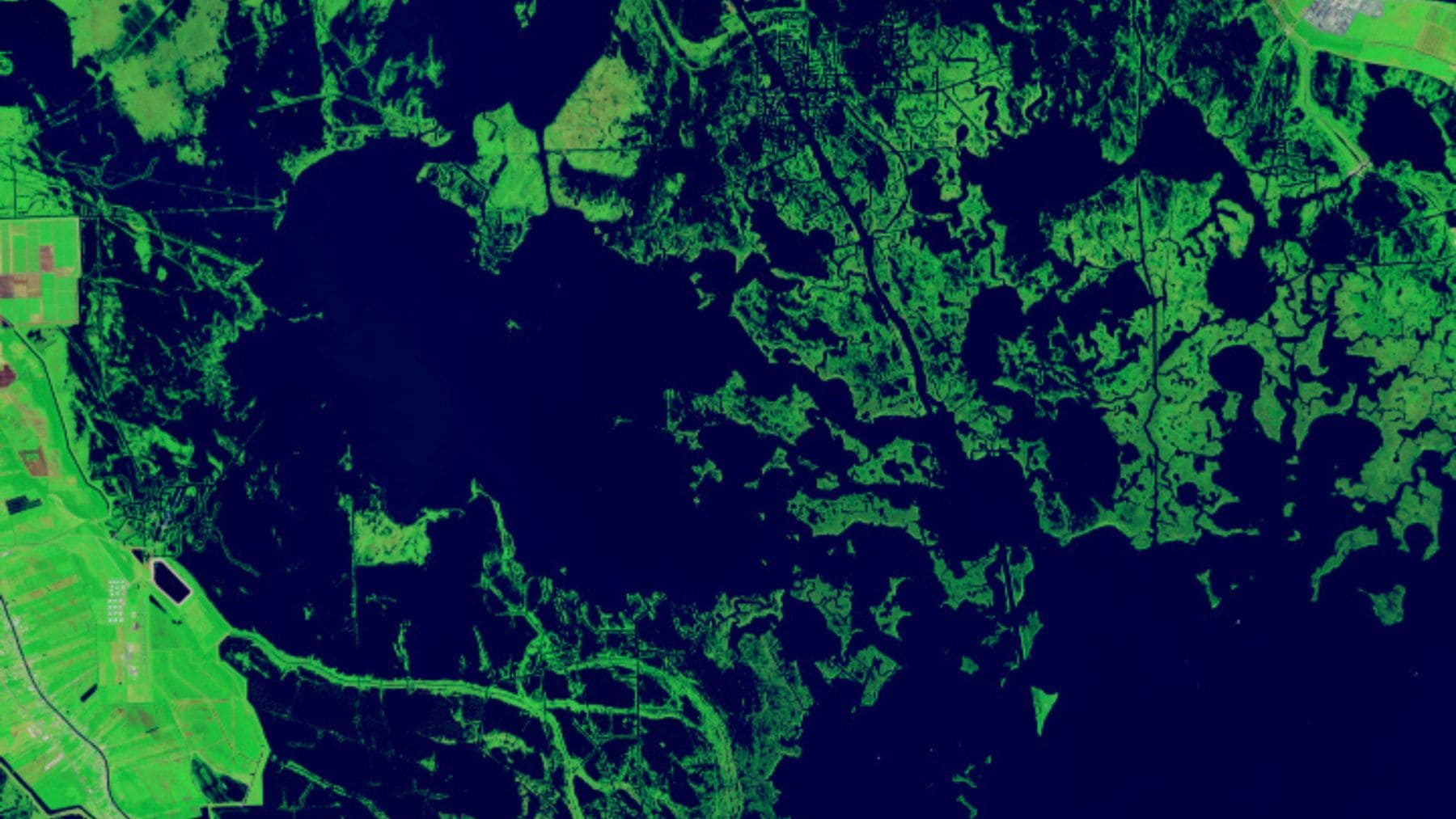 Imagen satelital de la NASA de un remolino oceánico en el Ártico canadiense visible como un círculo oscuro entre hielo y sedimentos.