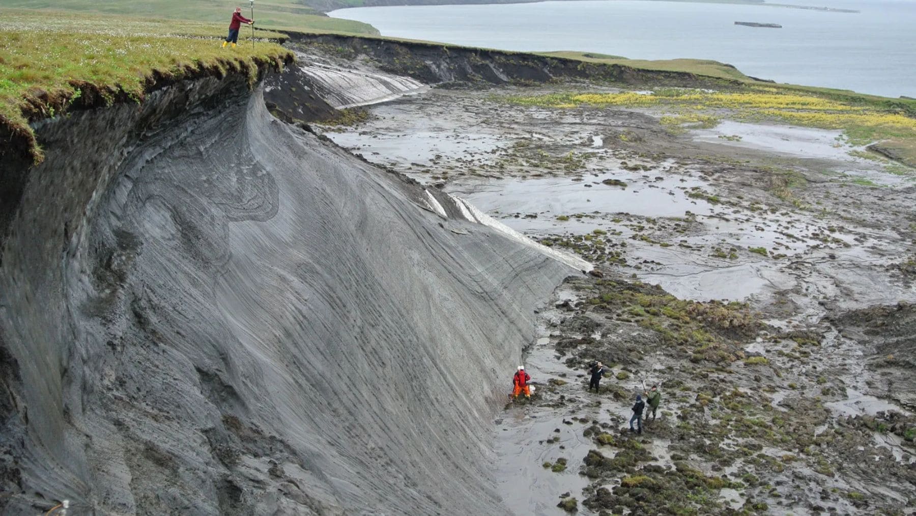 Deshielo del permafrost en el Ártico con científicos estudiando un colapso del terreno causado por el calentamiento global.
