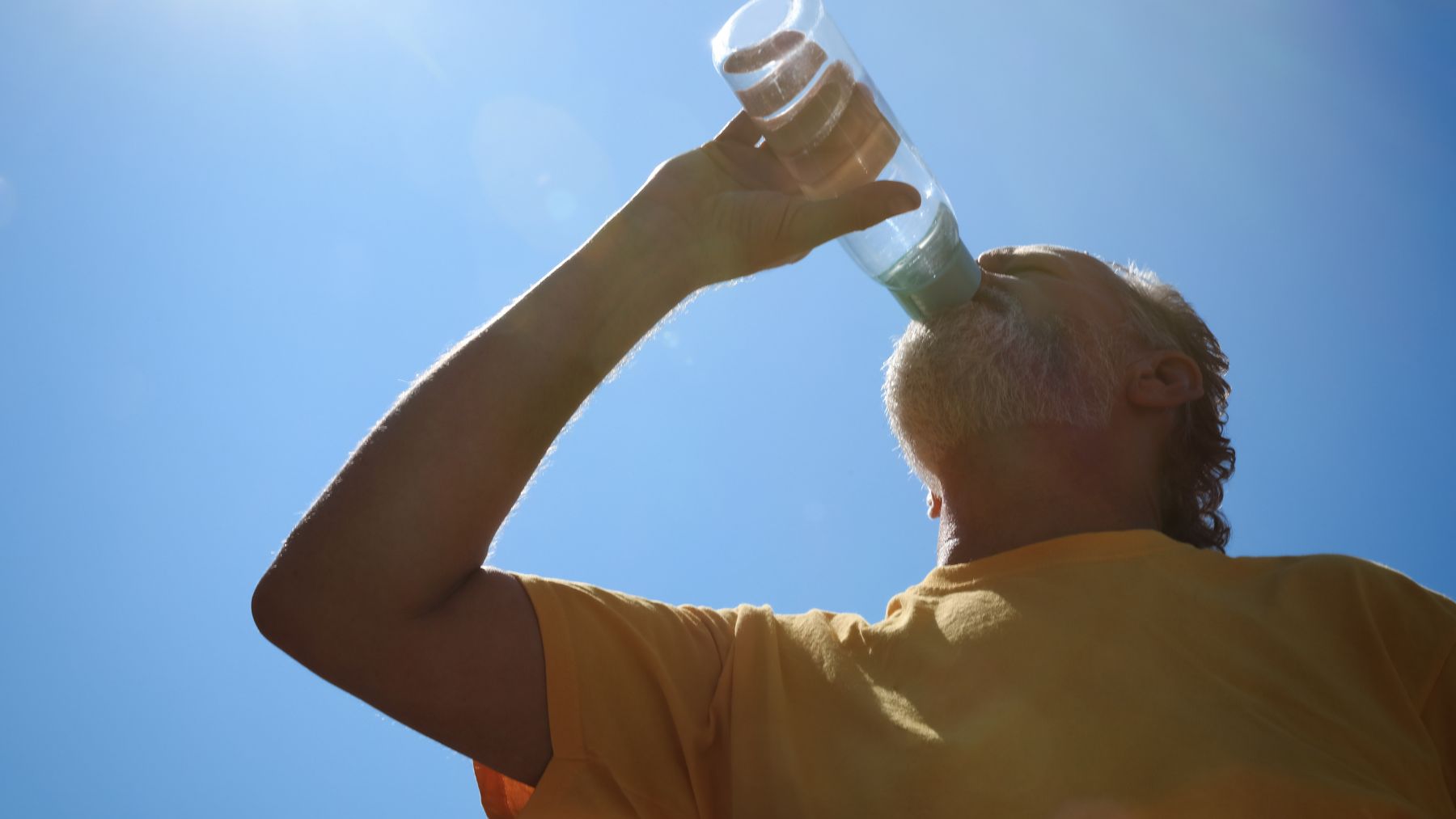 hombre bebiendo agua bajo calor extremo por altas temperaturas récord en 2025.