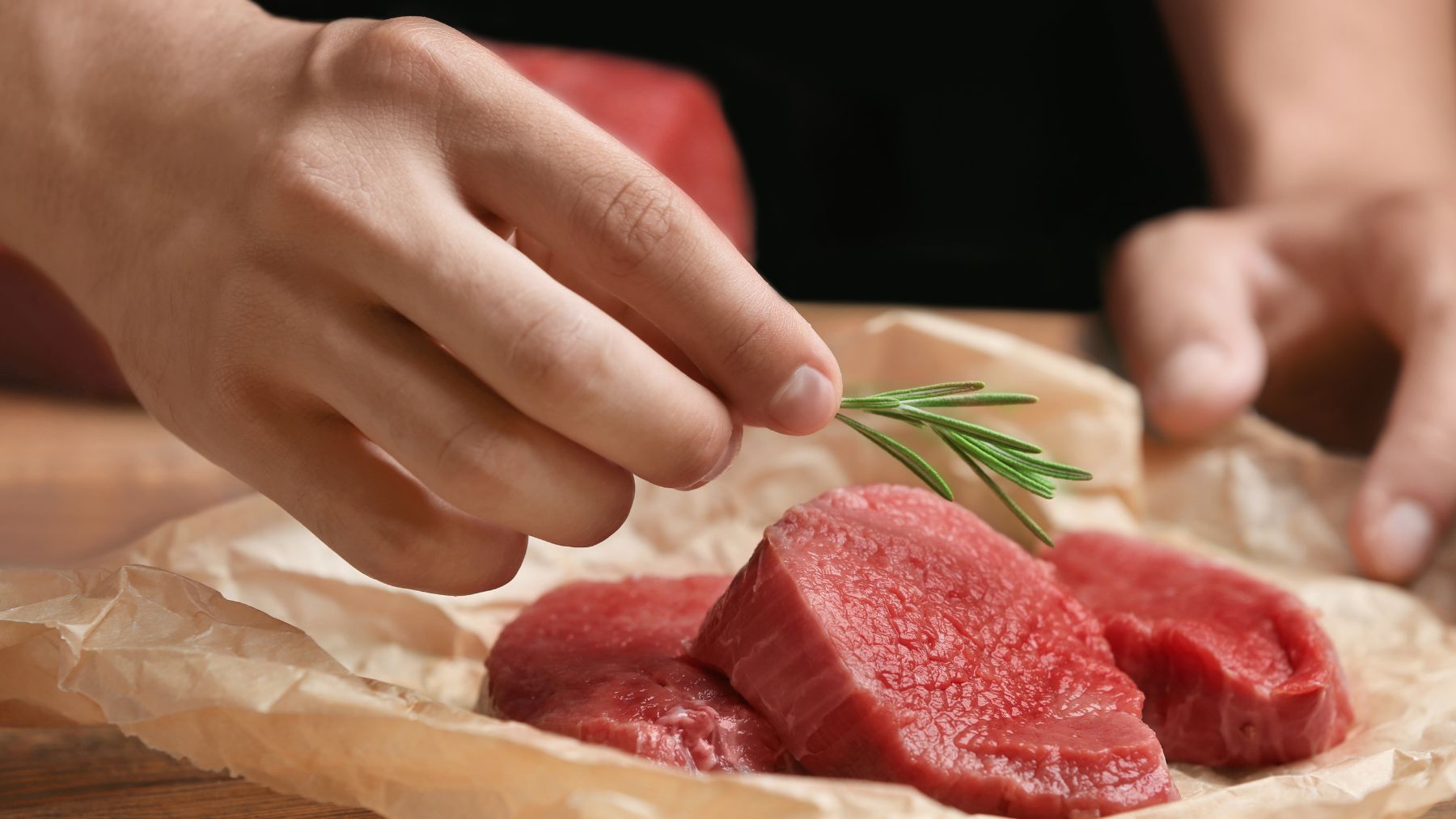 Carne de jabalí cruda magra con romero lista para cocinar, alternativa saludable al pollo y al pavo.