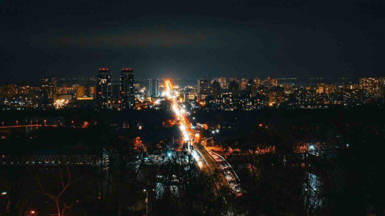 Contaminación lumínica en ciudad de noche con luces intensas afectando el entorno natural.
