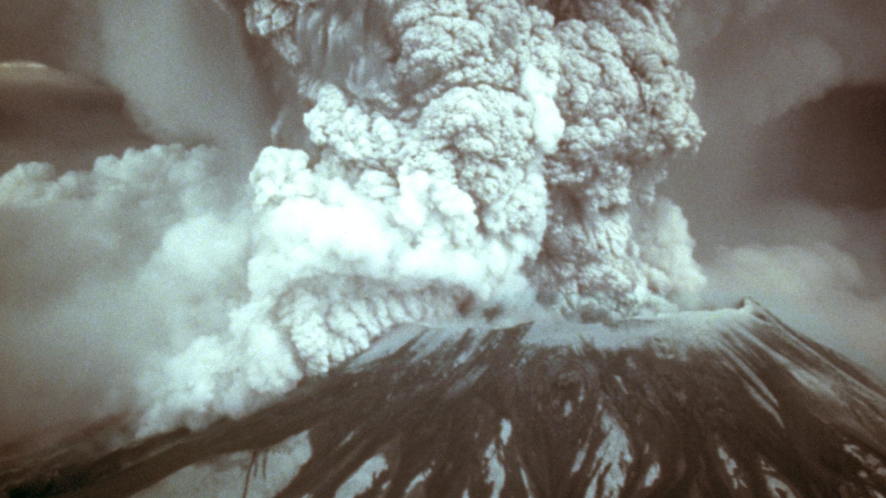 Erupción del Mount St Helens en 1980 con columna de ceniza tras el desastre que dejó el suelo estéril.