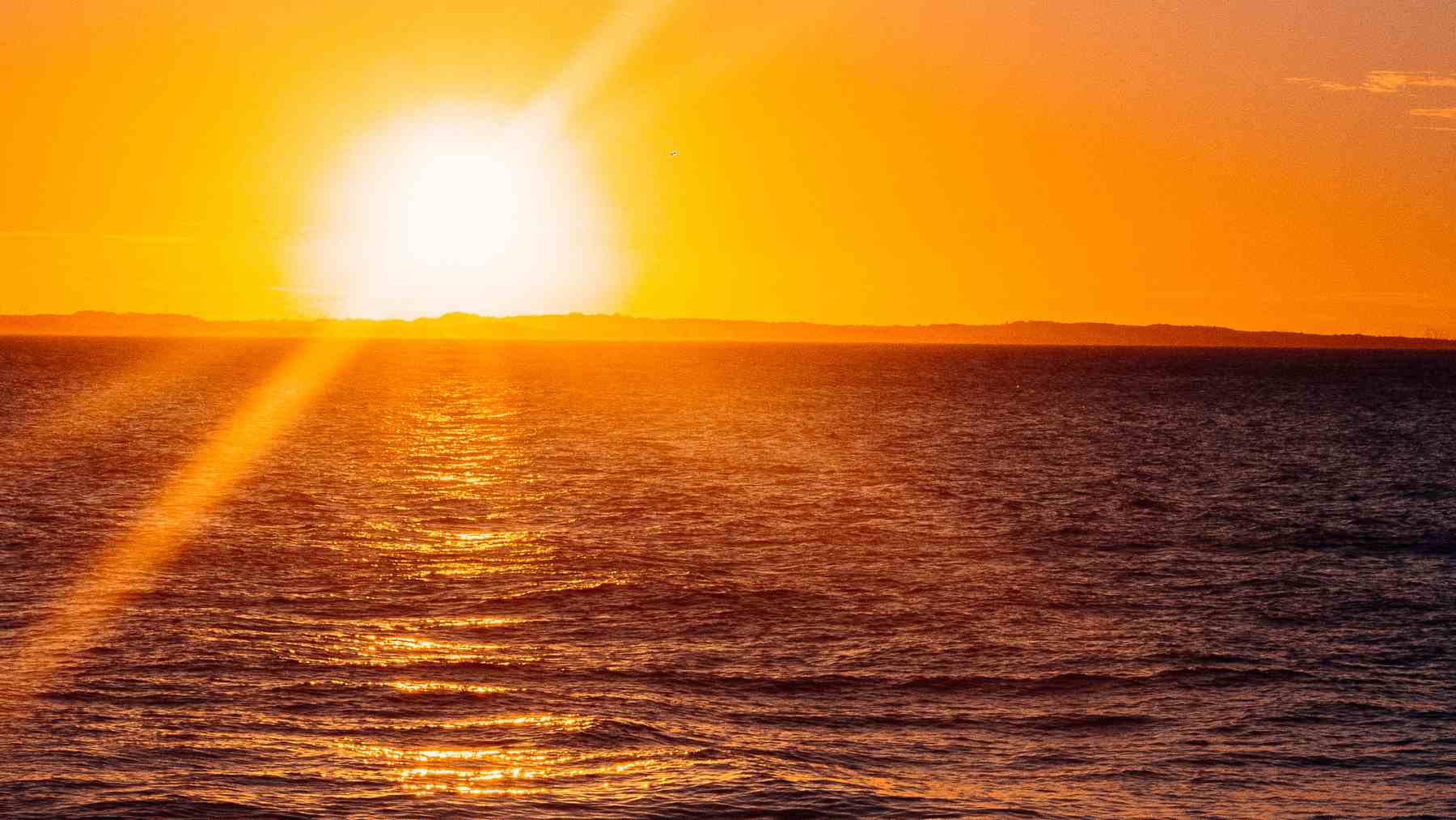 Ola de calor marina con el océano muy caliente al atardecer relacionada con huracanes intensos.