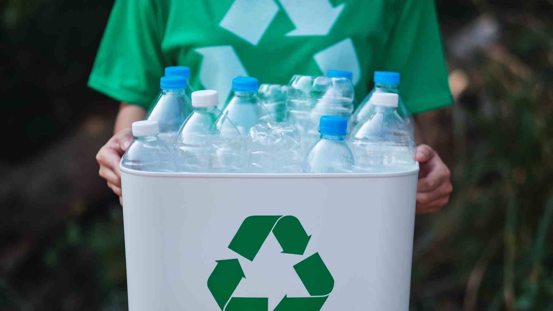 Persona reciclando botellas de plástico para devolverlas en supermercado con sistema SDDR en España.