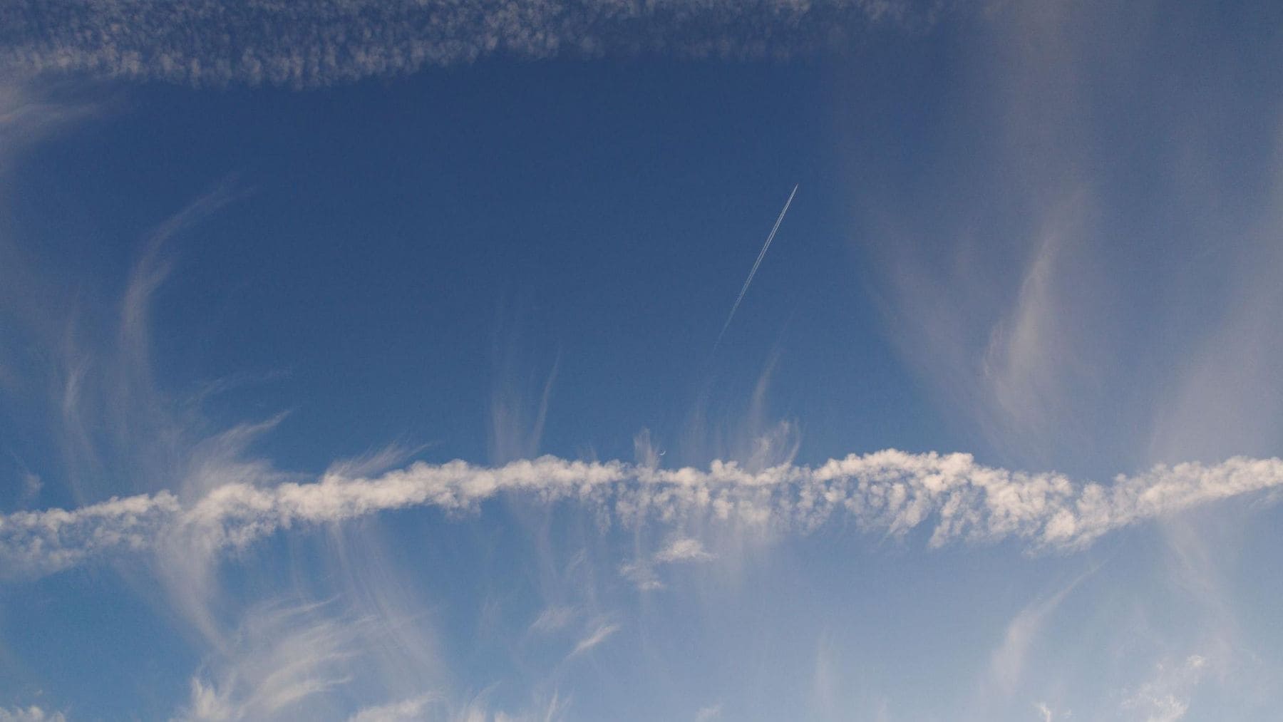 Estelas de condensación de aviones formando cirros artificiales relacionados con el cambio climático.