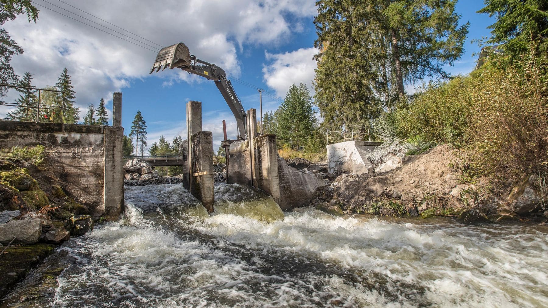 Excavadora retirando una antigua presa en un río europeo para restaurar la conectividad fluvial y los ecosistemas acuáticos.