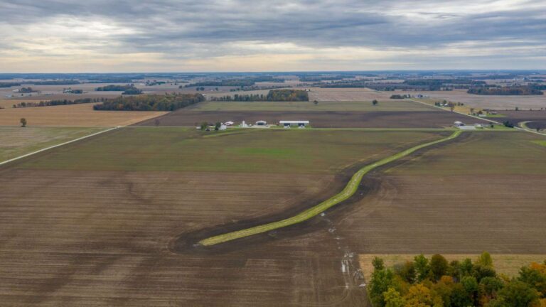 Vista aérea de campos de cultivo de Ohio atravesados por un cauce cubierto de hierba