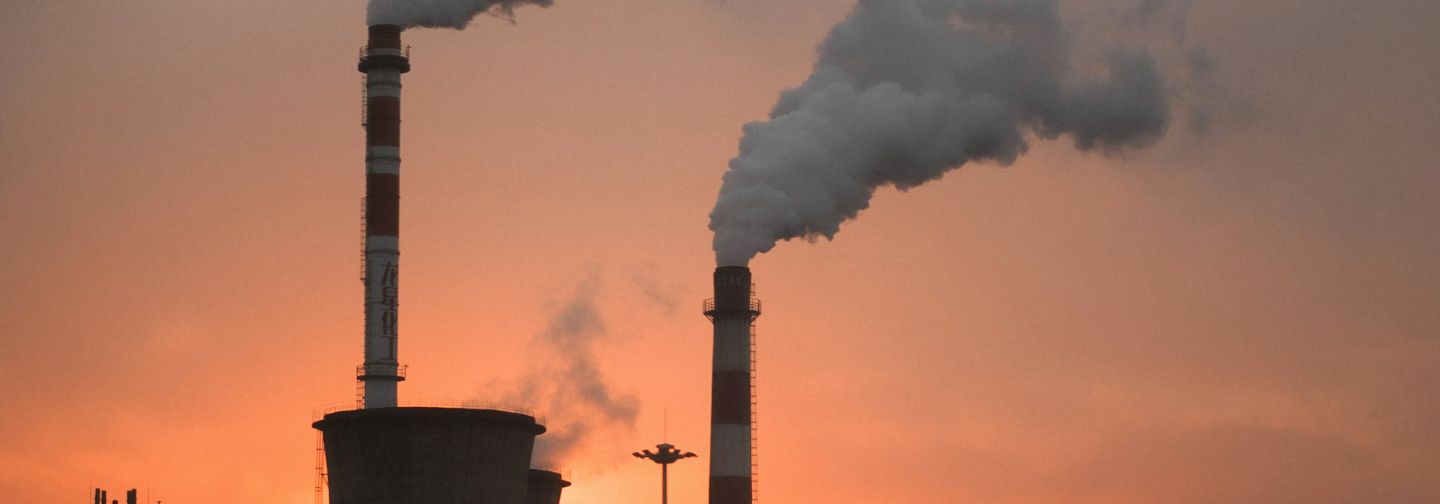 Chimeneas industriales emitiendo humo al atardecer