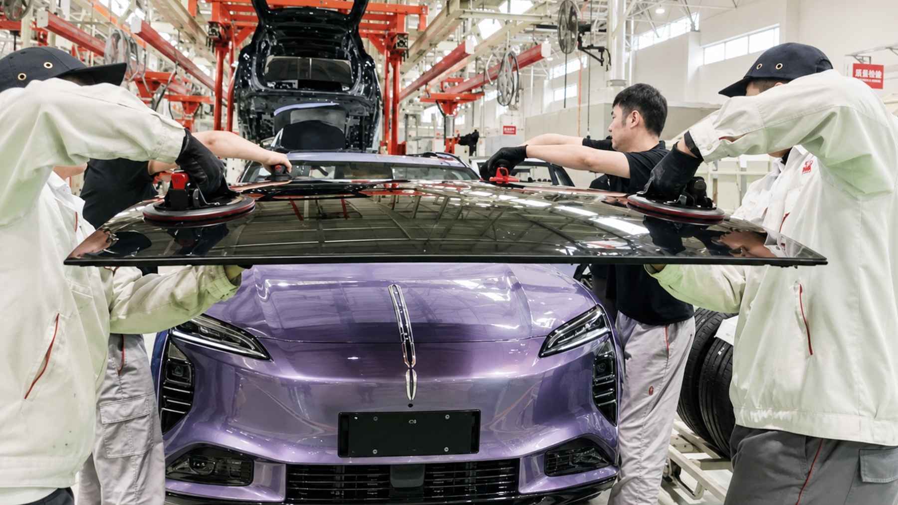 Operarios instalando un techo solar de perovskita en un coche eléctrico de China FAW