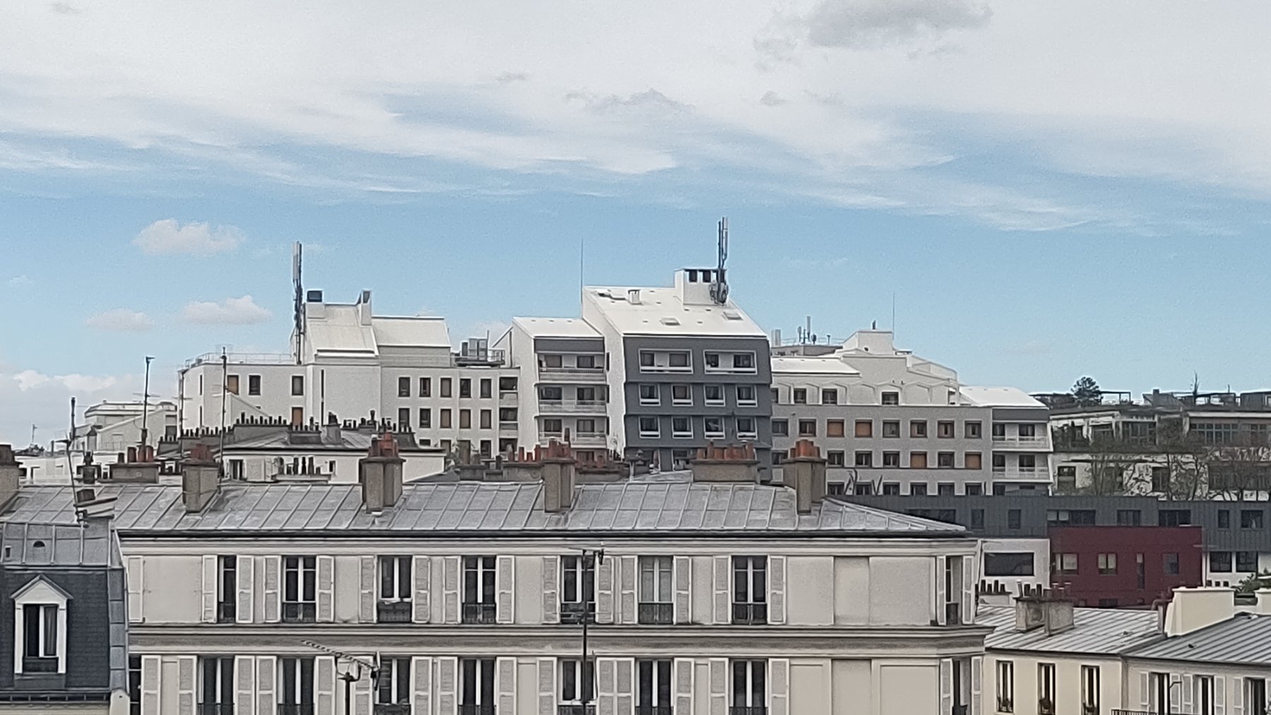 Tejados urbanos de colores claros que reflejan la luz del sol en una ciudad