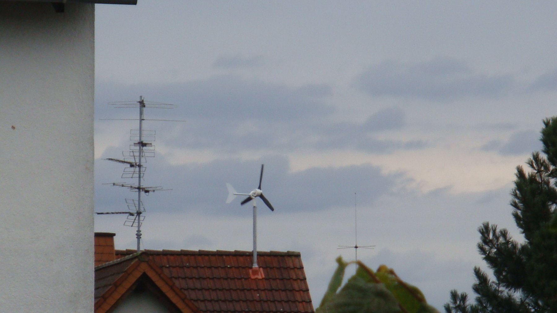 Pequeño aerogenerador doméstico instalado sobre el tejado de una vivienda