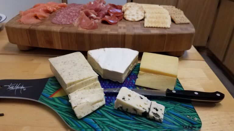 Tabla de madera con embutidos, quesos curados y pan