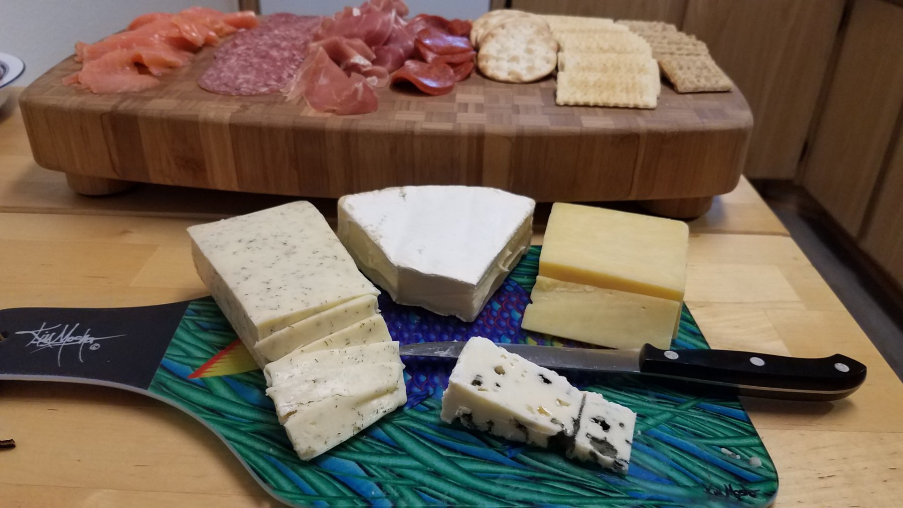 Tabla de madera con embutidos, quesos curados y pan
