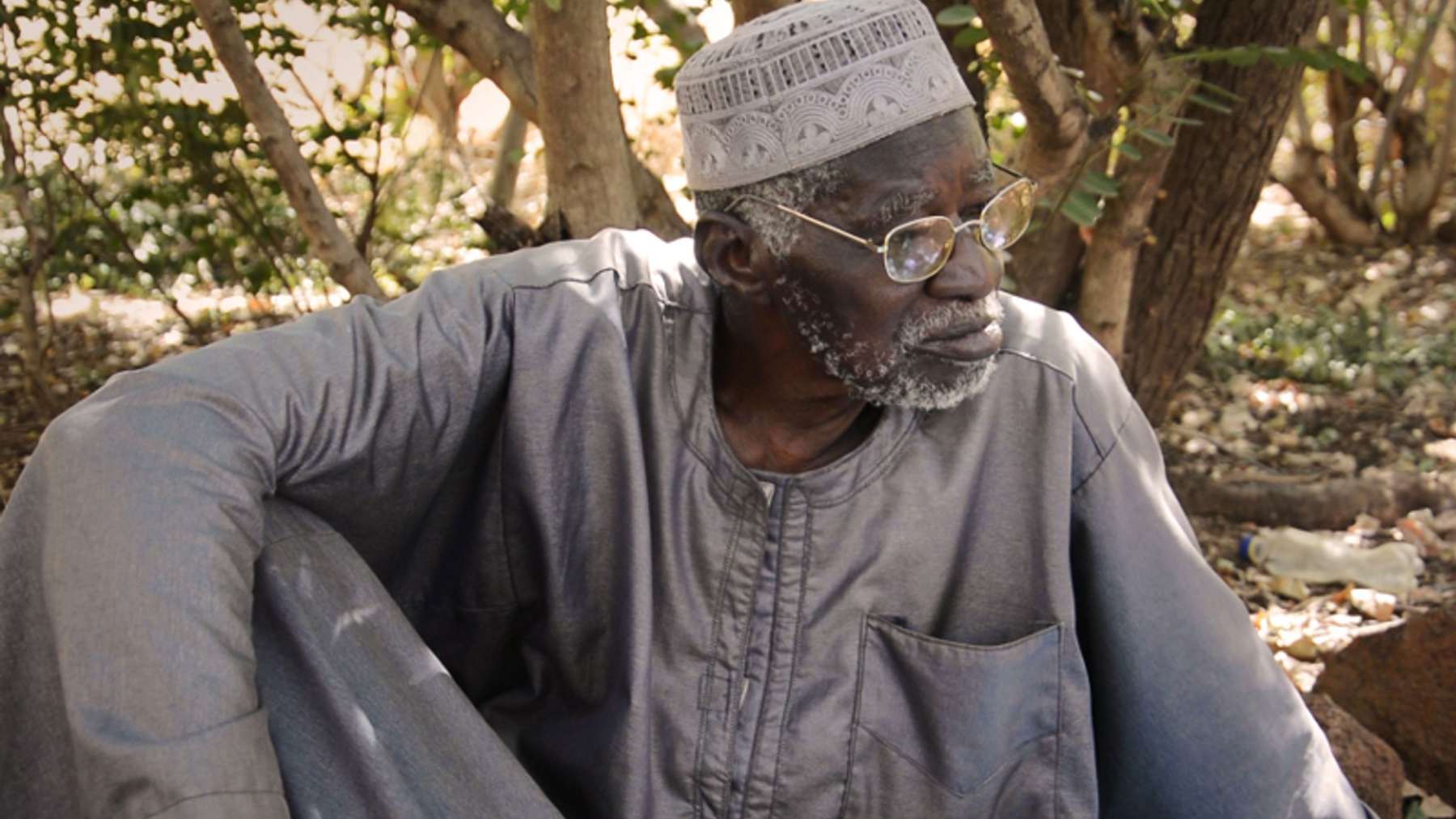 El agricultor burkinés Yacouba Sawadogo sentado junto a los árboles de su bosque