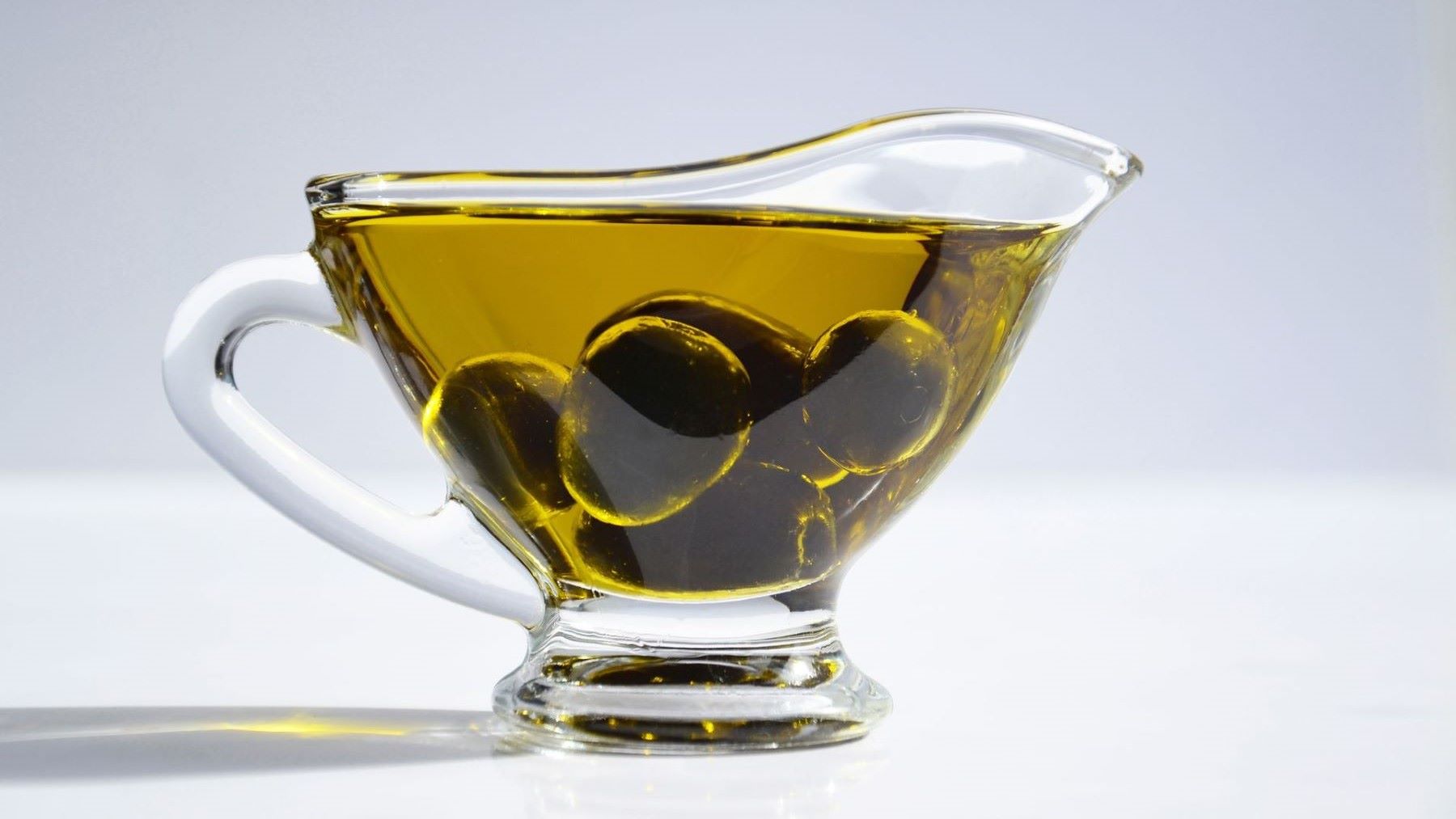 Aceite de oliva virgen extra servido sobre un plato de verduras