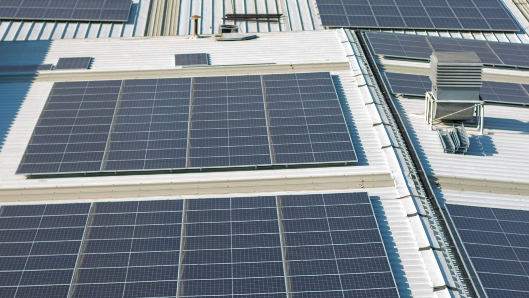 Paneles solares y equipo de climatización en un edificio, tecnologías contempladas en las ayudas Eguzki Hotz